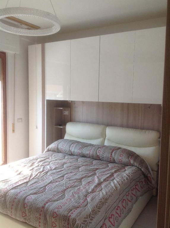 a bedroom with a large bed with white cabinets at Appartamento Bellavista in Castiglione della Pescaia