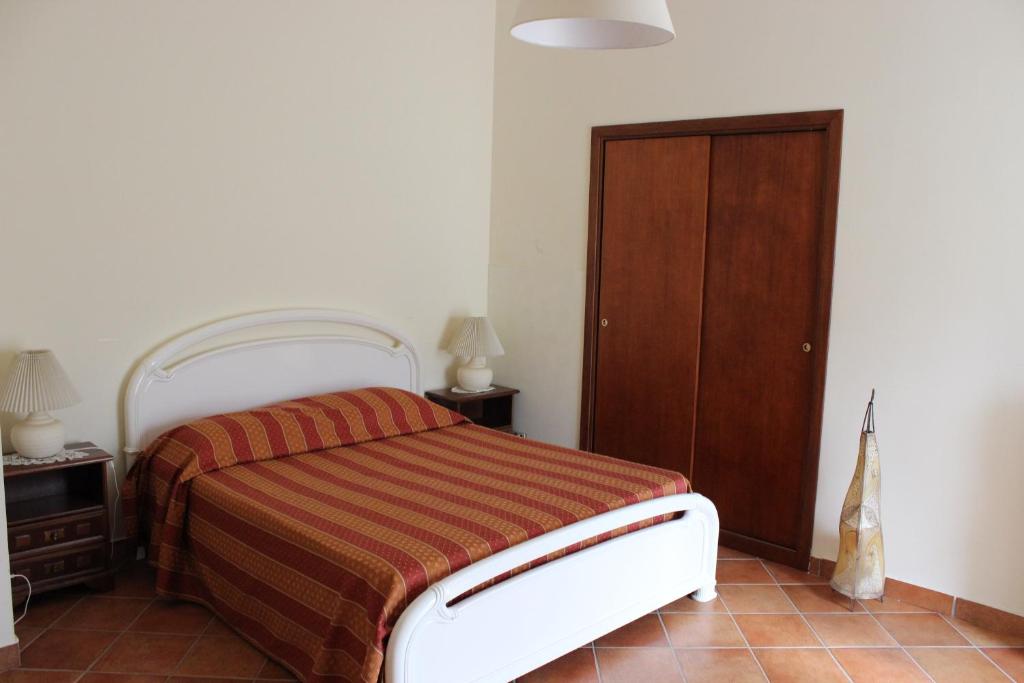 1 dormitorio con 1 cama y armario de madera en B&B Villa Ursa Major, en Vico Equense