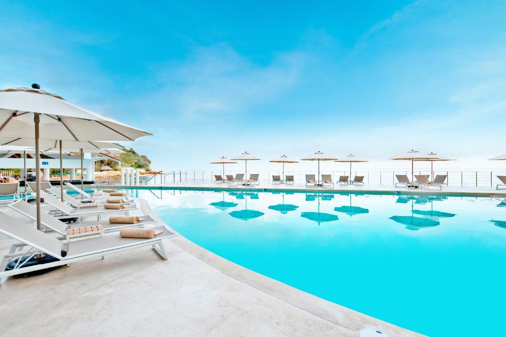 a swimming pool with chairs and umbrellas at Grand Park Royal Puerto Vallarta - All Inclusive in Puerto Vallarta