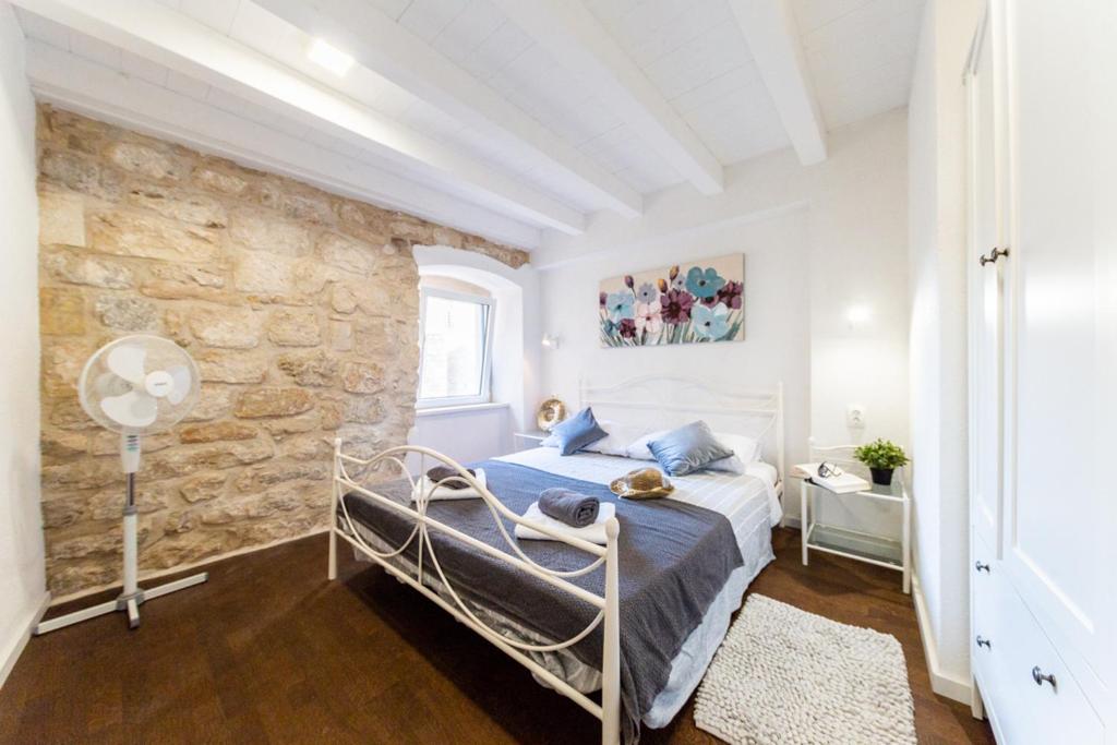 a bedroom with a bed and a stone wall at Casa Karina in Vis