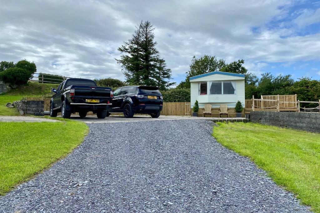 two trucks parked in front of a tiny house at Snowdon Bay - North Wales - Stunning Llyn Peninsula Mountain & Ocean Views in Pwllheli