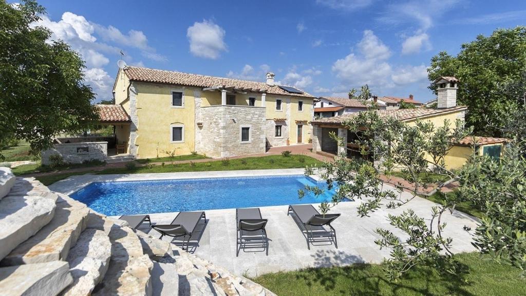 a villa with a swimming pool in front of a house at Authentic Istrian Villa Ive with a swimming pool in Marčana