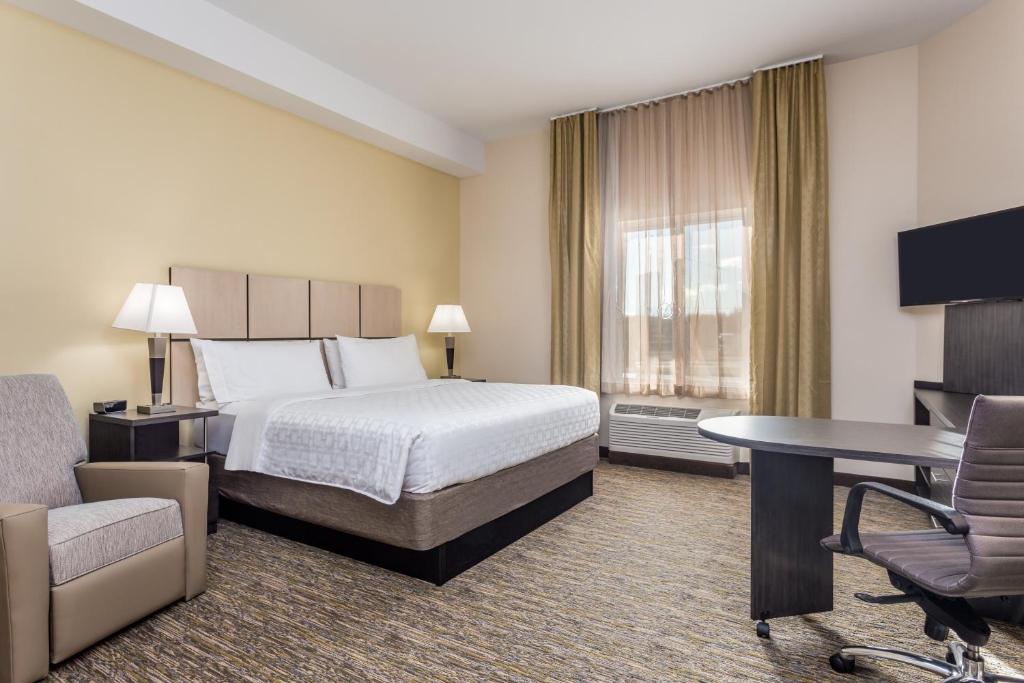 a hotel room with a bed and a desk at Candlewood Suites Bethlehem South by IHG in Bethlehem