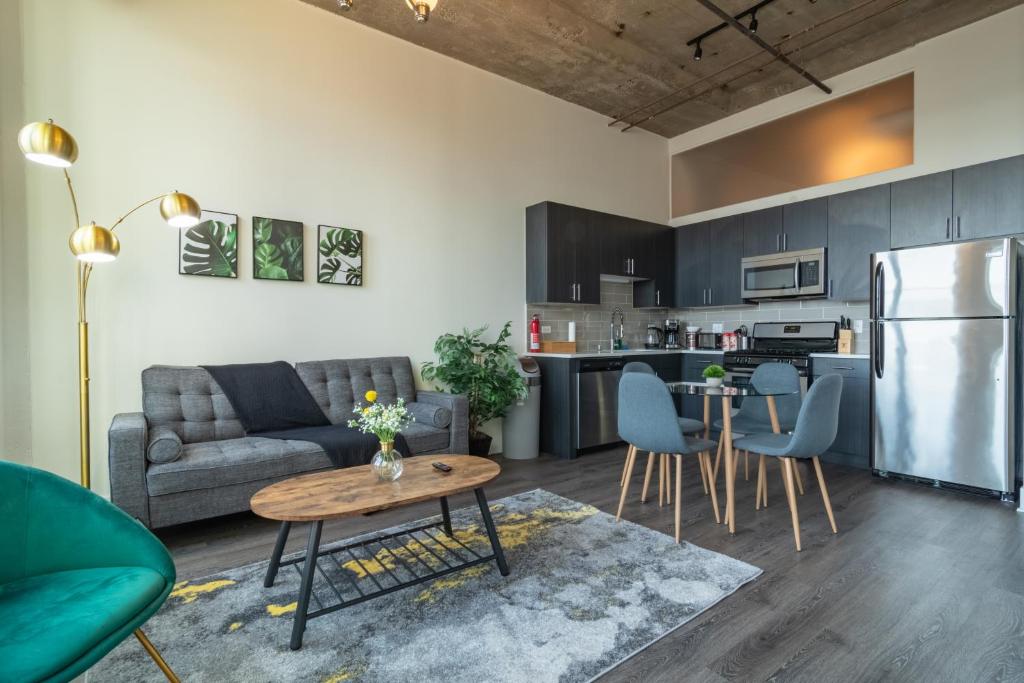 uma cozinha e sala de estar com um sofá e uma mesa em McCormick Place 2b-2b family unit with optional parking sleeps up to 6 em Chicago