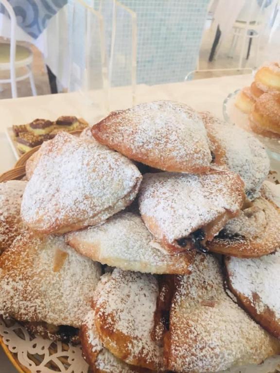a pile of powdered donuts sitting on a plate at Hotel Milanese in Rimini