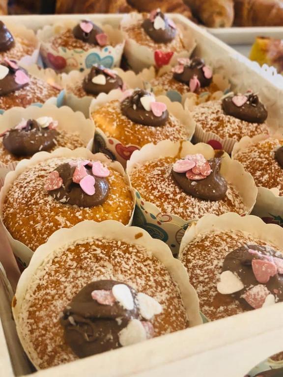 a tray of donuts with chocolate and pink sprinkles at Hotel Milanese in Rimini