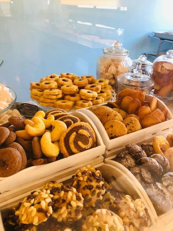 a bunch of different types of donuts on a table at Hotel Milanese in Rimini