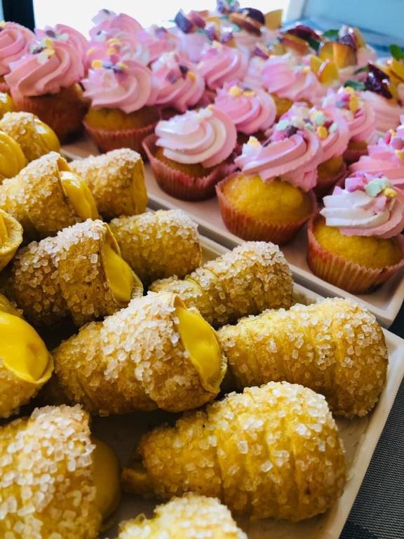 a tray of cupcakes and muffins on a table at Hotel Milanese in Rimini