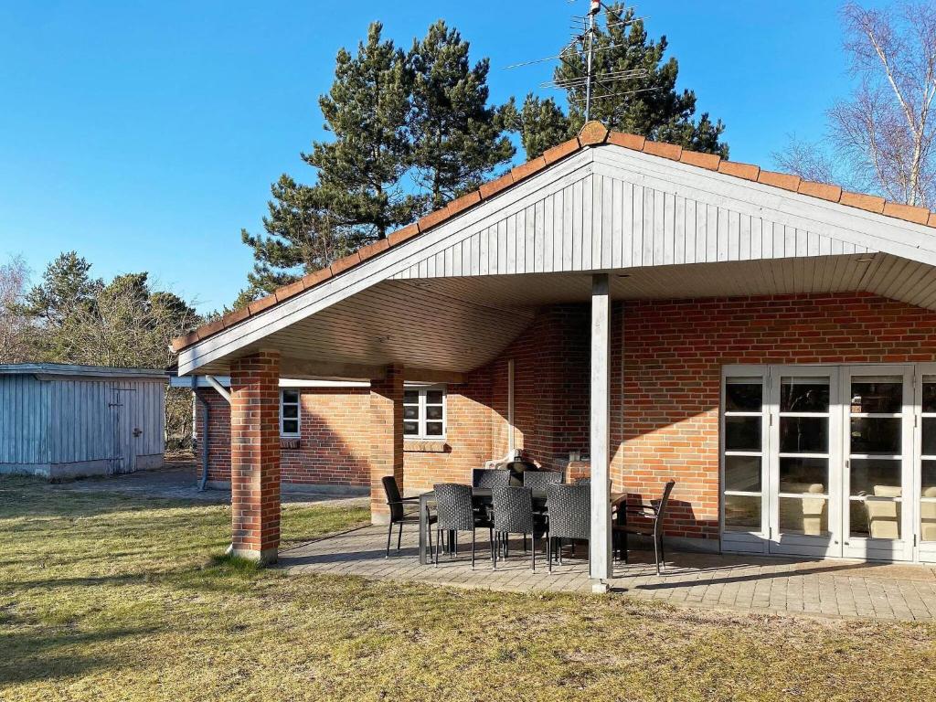 Casa de ladrillo con patio con mesas y sillas en 8 person holiday home in R dby, en Kramnitse