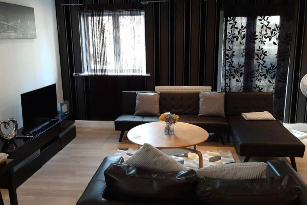 uma sala de estar com um sofá e uma mesa em Modern 2 Bed Apartment by BellaLiving em Luton