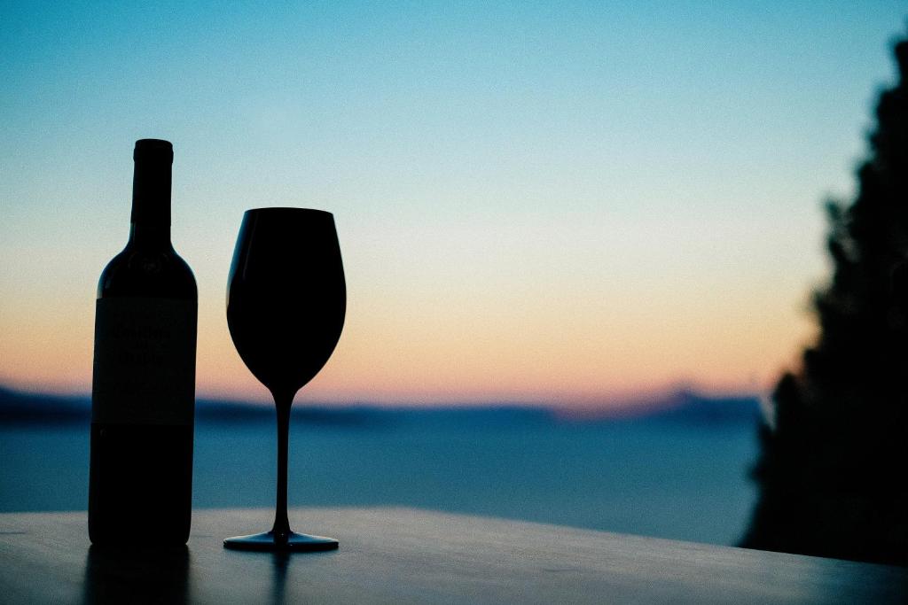 una botella de vino y una copa de vino en una mesa en Lake View Bariloche en San Carlos de Bariloche