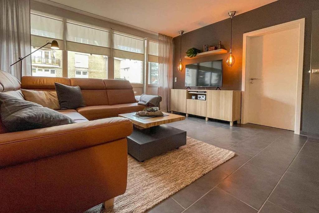 ein Wohnzimmer mit einem Sofa und einem TV in der Unterkunft Ferienwohnung 41 mit perfekter Ausstattung, Residenz Meeresbrandung Duhnen in Cuxhaven