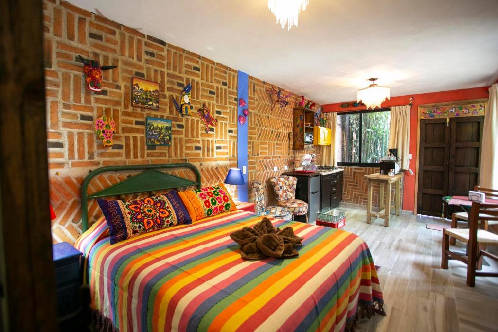 - une chambre avec un lit et une couverture colorée dans l'établissement Majikal B&B - Alebrijes, à Cholula