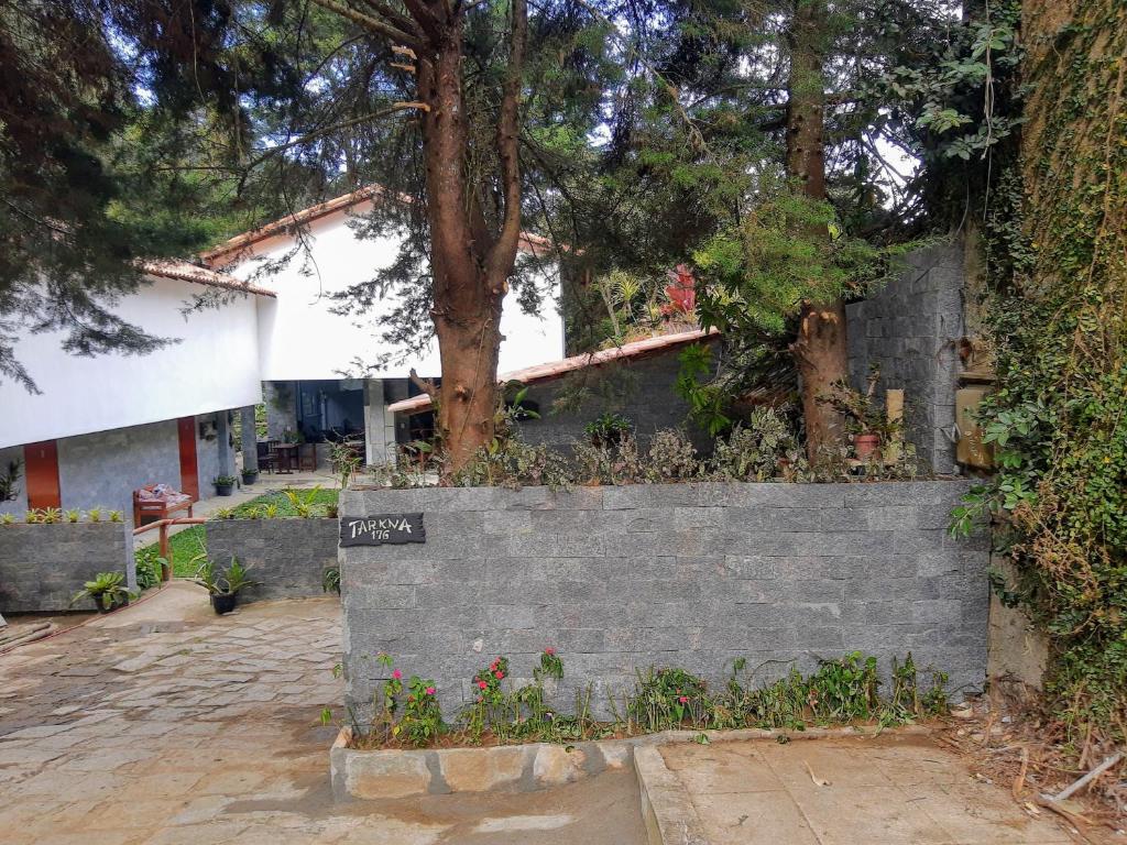 a concrete retaining wall with a tree behind it at Pousada Tarkna in Teresópolis