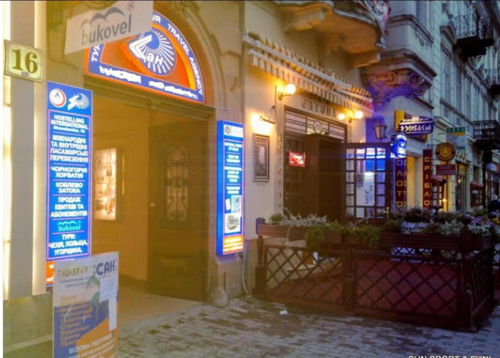 een gebouw met borden aan de straatkant bij Hotel Sun in Lviv