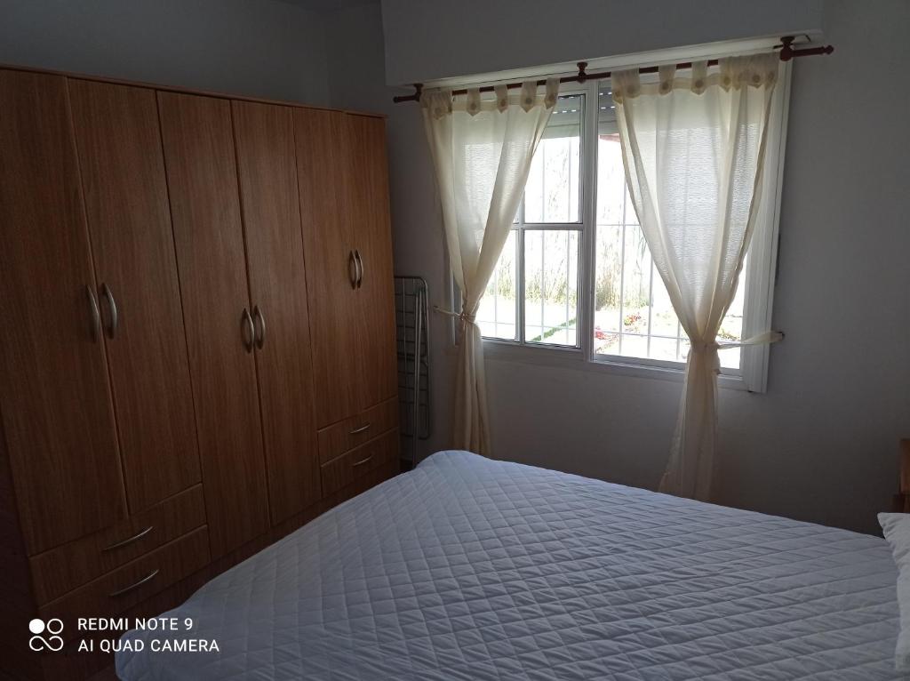 een slaapkamer met een bed en een raam bij La posada del Nono in Villa Gesell