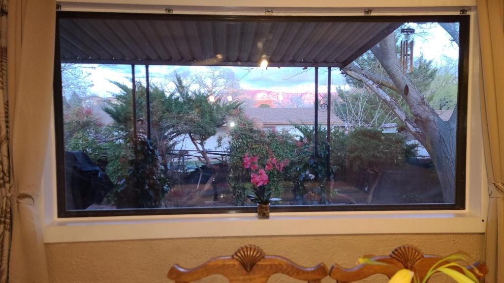 a window with a vase with flowers in it at Charming home with red rock view, near Stupa and trails, with UV light air filters in Sedona