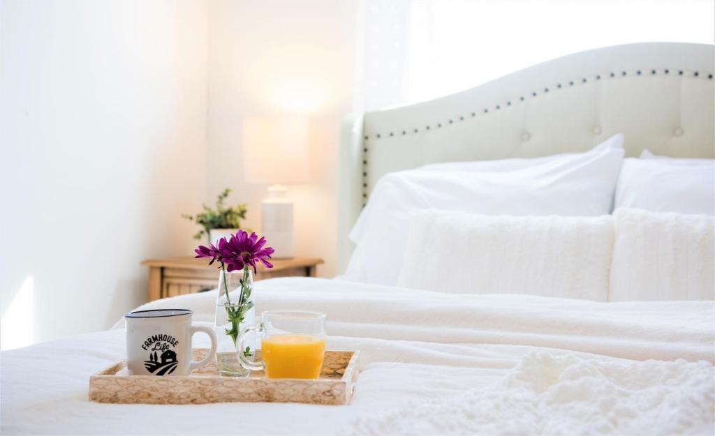 een dienblad met twee glazen sinaasappelsap op een bed bij Inn on Golden Pond in Holderness