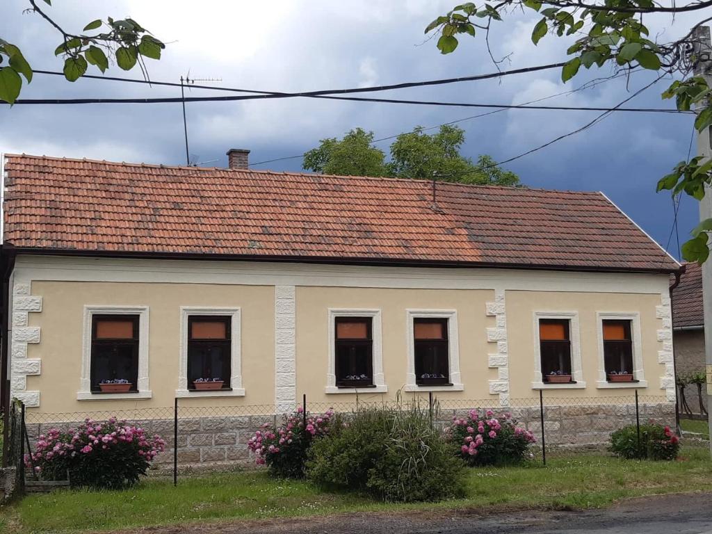 una casa con ventanas y techo rojo en Szőlőskert Vendégház, Erdőbénye, en Erdőbénye
