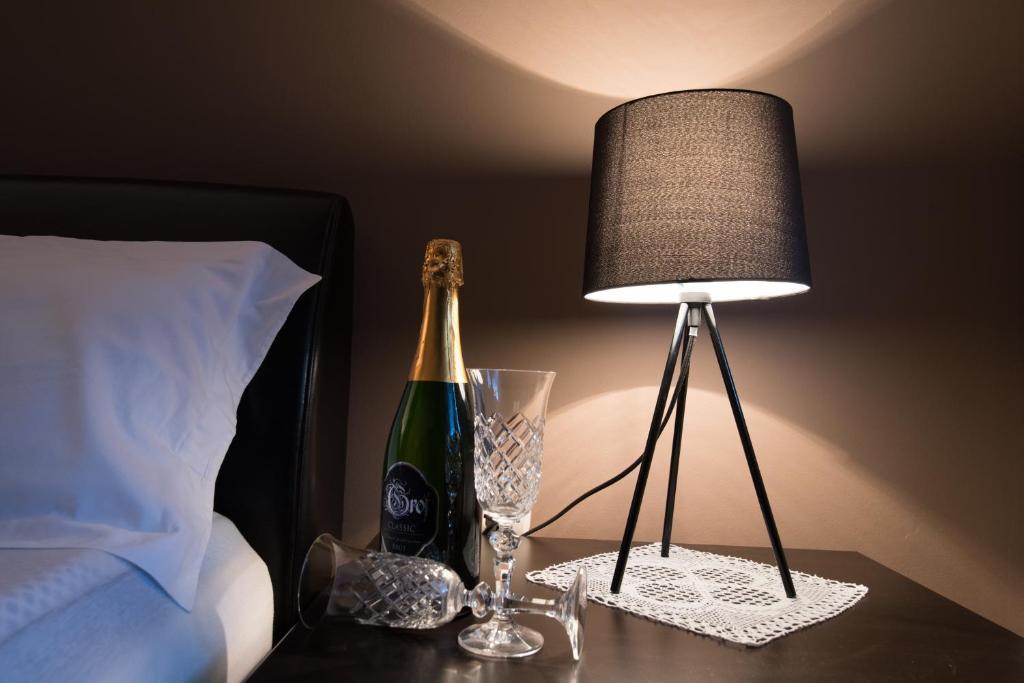 una bottiglia di champagne su un tavolo accanto a una lampada di VILLA MARIA Požega a Požega