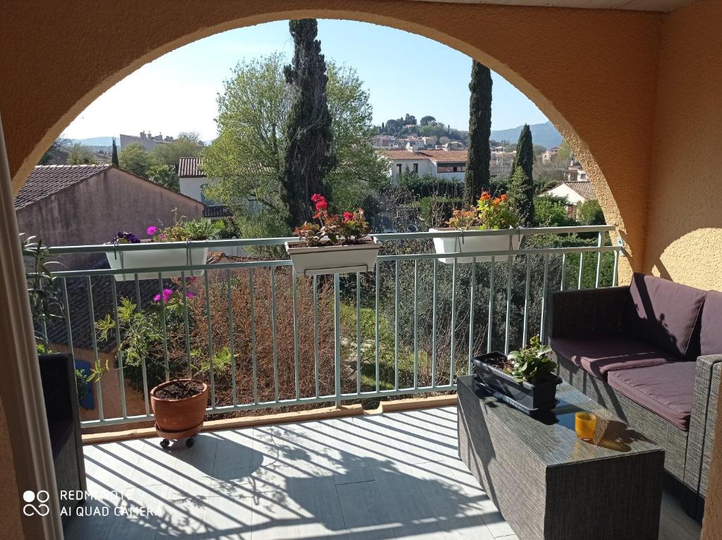 a balcony with a view of a garden at Un nid d'amour en Provence à deux pas de la mer in Cogolin