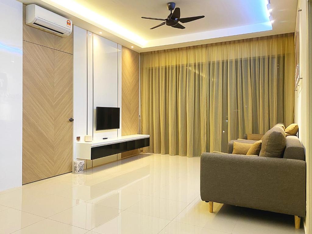 a living room with a couch and a flat screen tv at Amadel Residence 爱媄德民宿 11 in Malacca