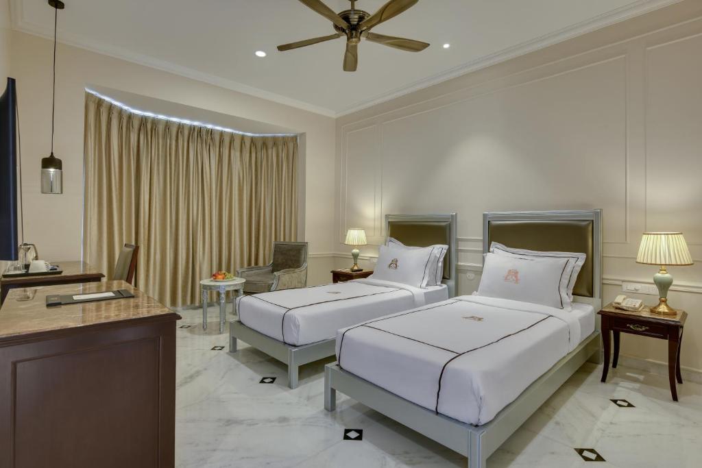 a hotel room with two beds and a table at SHAHPURA DEV PANACHE in Udaipur