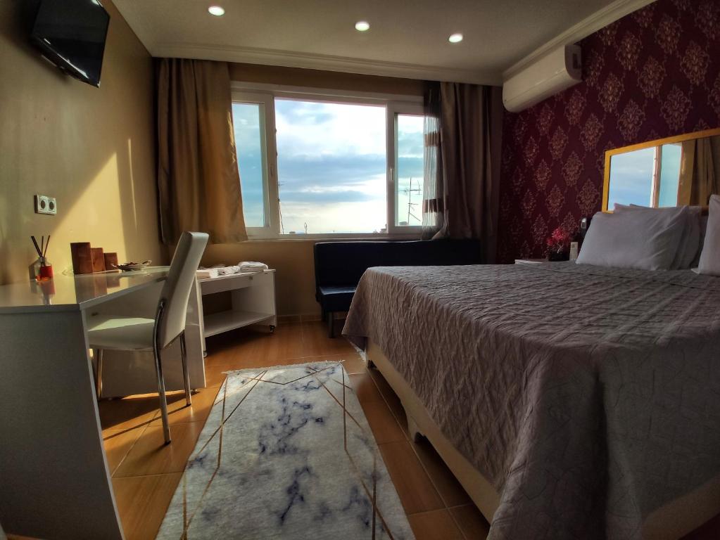 a bedroom with a bed and a desk and a window at Hotel Best Apart in Istanbul
