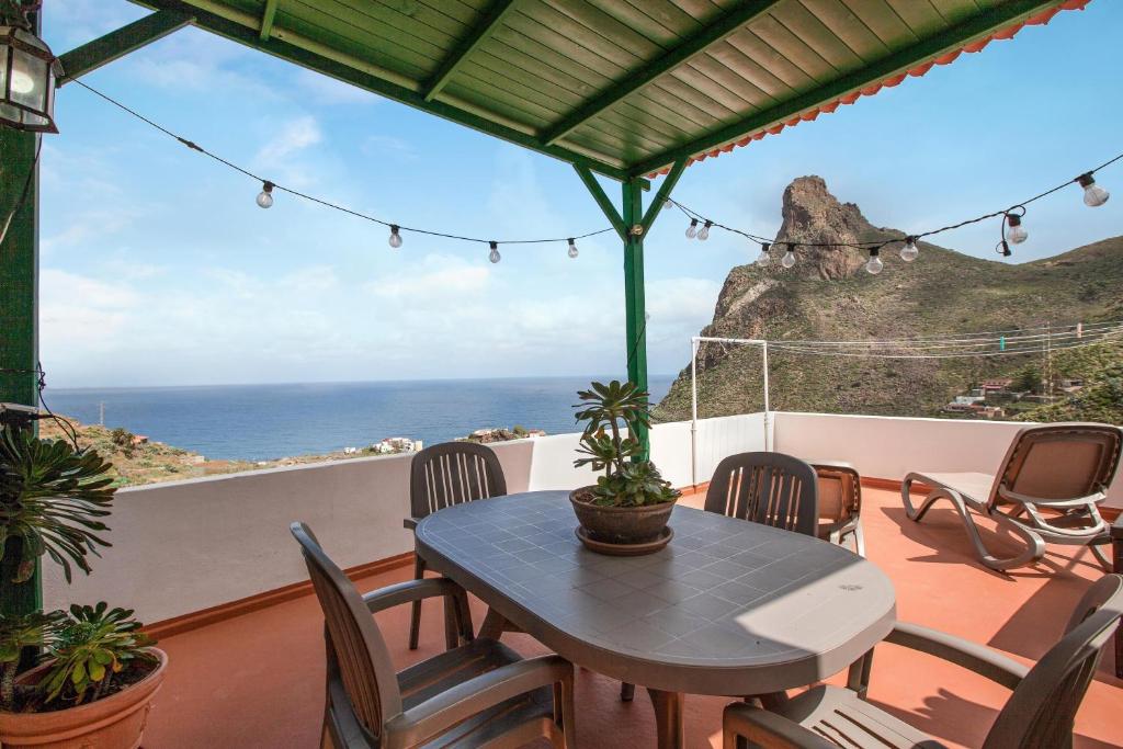 un tavolo e sedie su un balcone con vista sull'oceano di Casa Taganana a Santa Cruz de Tenerife
