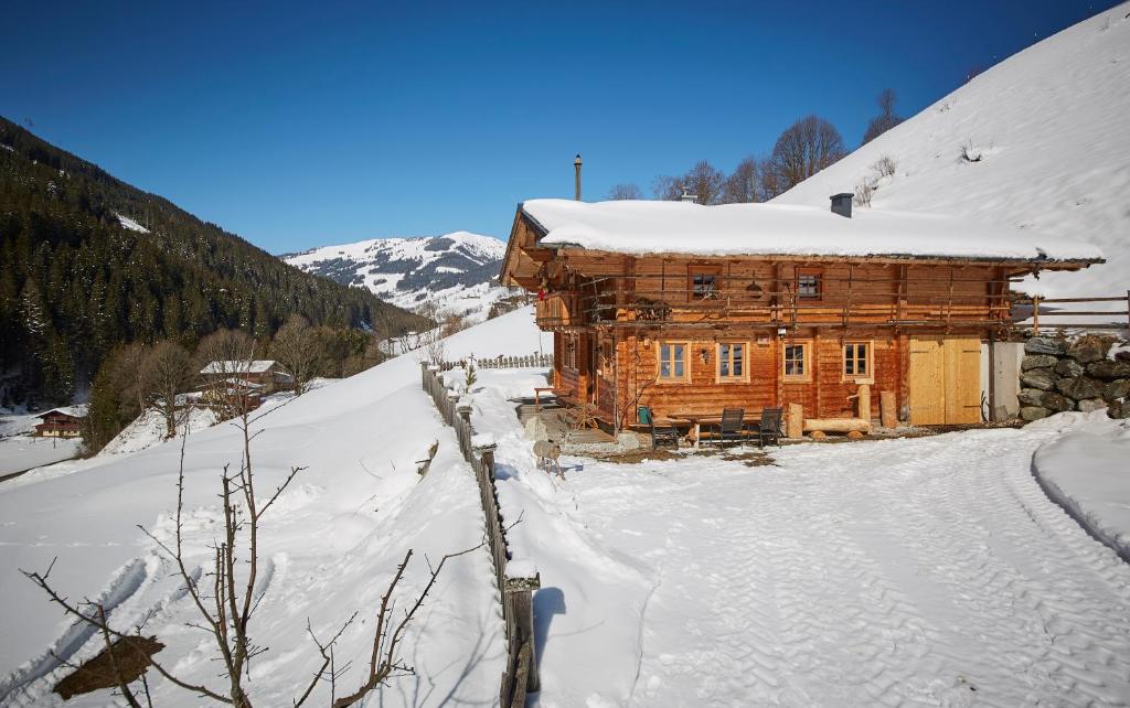 una cabaña de madera en la nieve en las montañas en Woodstyle Chalet en Saalbach Hinterglemm