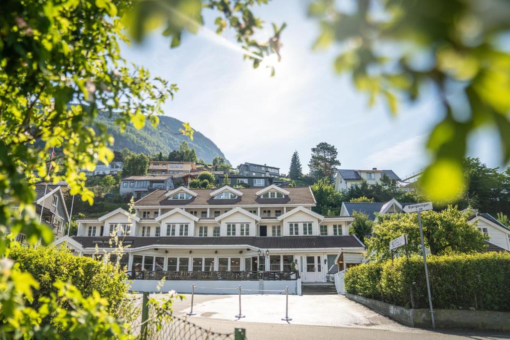 een groot wit huis met een berg op de achtergrond bij Hotel Aurlandsfjord in Aurland