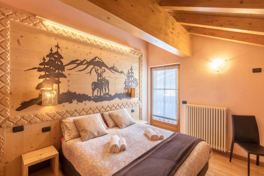 a bedroom with a bed with two towels on it at Zenith - Casa Azzurra Mansarda in Livigno