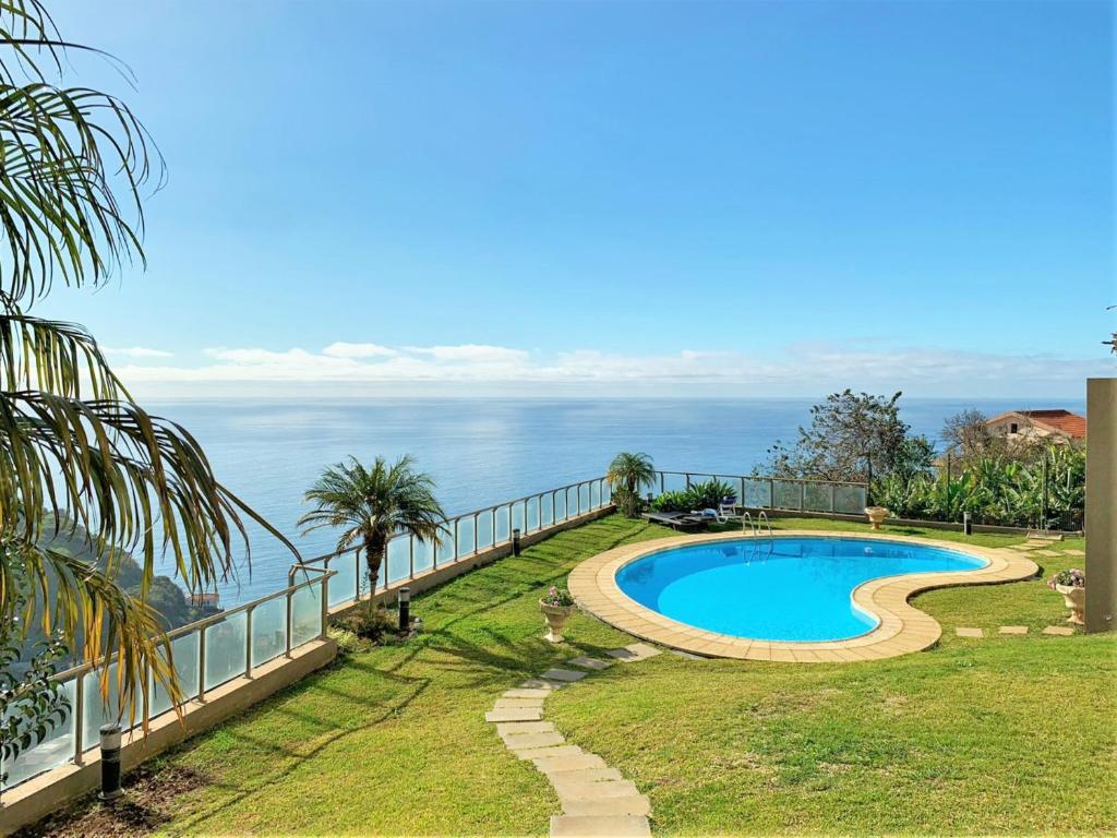 a swimming pool with the ocean in the background at Charming Calheta Plaza Penthouse in Calheta