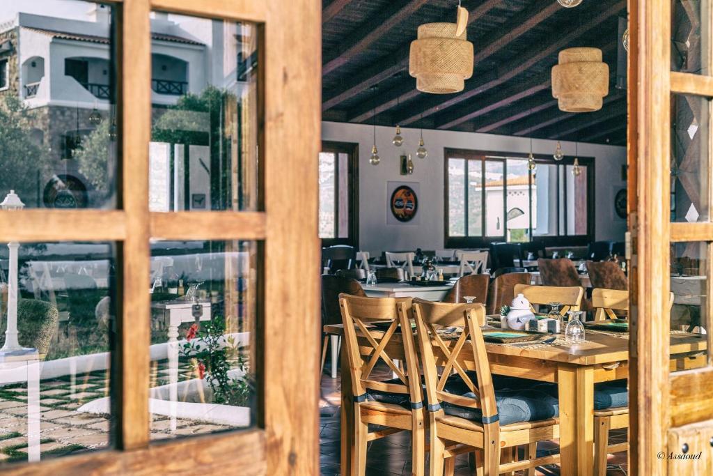 - une salle à manger avec une table et des chaises en bois dans l'établissement Room in Bungalow - Bungalow Double 4 - El Cortijo Chefchaeun Hotel Spa, à Chefchaouen