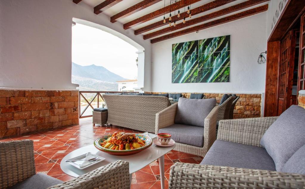 a living room with chairs and a bowl of food on a table at Room in Bungalow - Bungalow Double 7 - El Cortijo Chefchaeun Hotel Spa in Chefchaouen