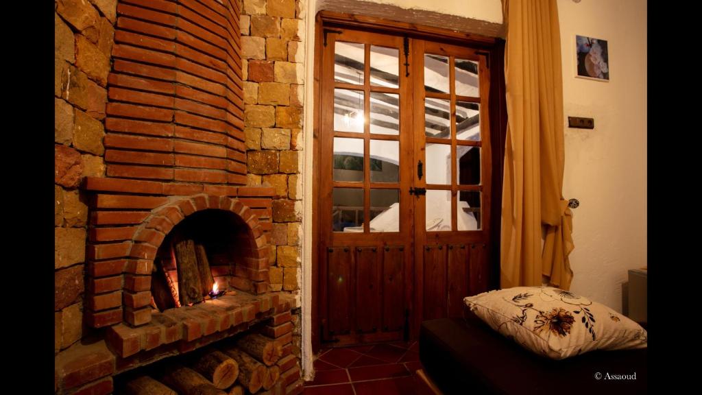 a room with a brick fireplace next to a door at Bungalow Double 9 - El Cortijo Chefchaeun Hotel Spa in Chefchaouene