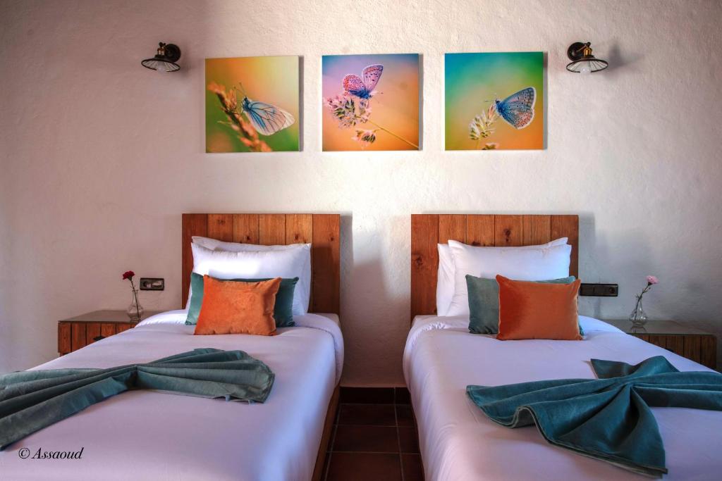 two beds in a room with paintings on the wall at Bungalow Double 15 - El Cortijo Chefchaeun Hotel Spa in Chefchaouene