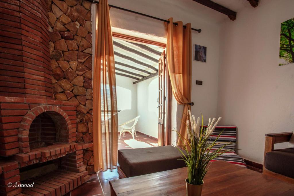 ein Wohnzimmer mit Kamin und Ziegelwand in der Unterkunft Room in Bungalow - Bungalow Double 18 - El Cortijo Chefchaeun Hotel Spa in Chefchaouen