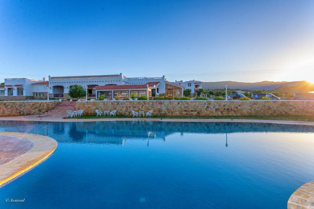 a large swimming pool with chairs in front of a building at Bungalow double 20 - El Cortijo Chefchaoeun Hotel Spa in Chefchaouene