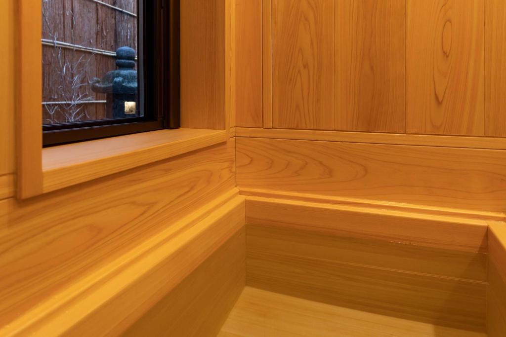 an empty room with a window and wooden floors at 祇園の宿 杏花 in Kyoto