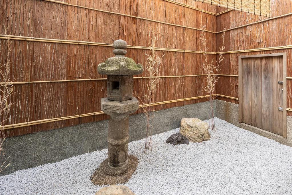 a stone statue in front of a wooden wall at 祇園の宿 杏花 in Kyoto