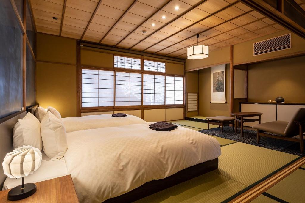 a bedroom with a large white bed and a desk at 祇園の宿 杏花 in Kyoto