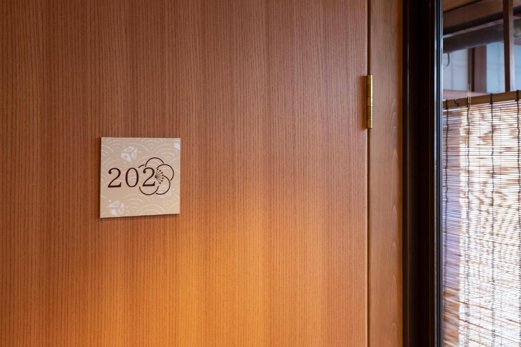 a door with a sign that says on it at 祇園の宿 杏花 in Kyoto