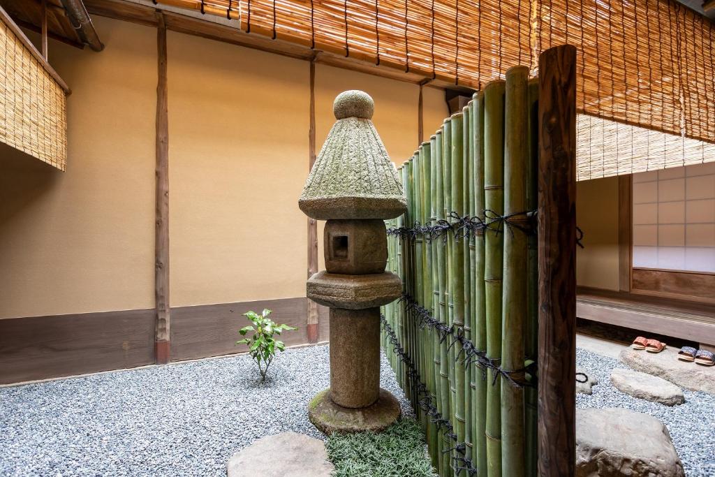 a stone bird feeder in front of a fence at 祇園の宿 杏花 in Kyoto