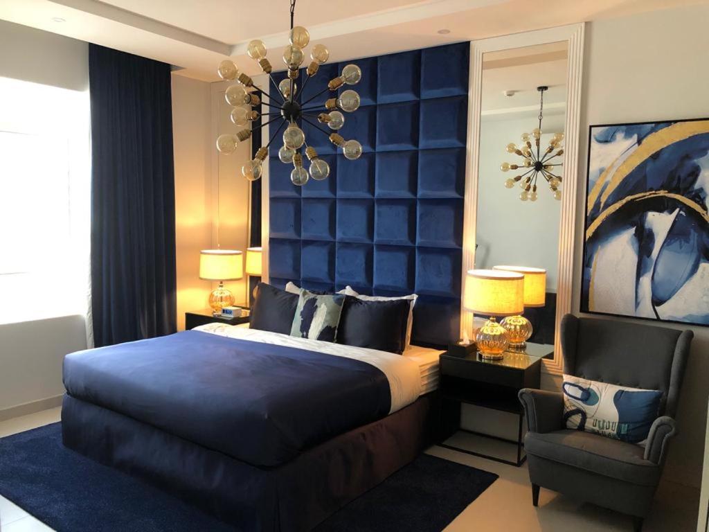 sypialnia z łóżkiem, krzesłem i żyrandolem w obiekcie Dana Hotel & Residences 2 w Rijadzie