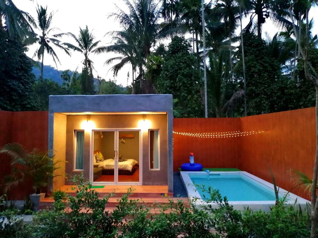 una pequeña casa con una piscina y una cama en ella en Anita dream house, en Khao Sok