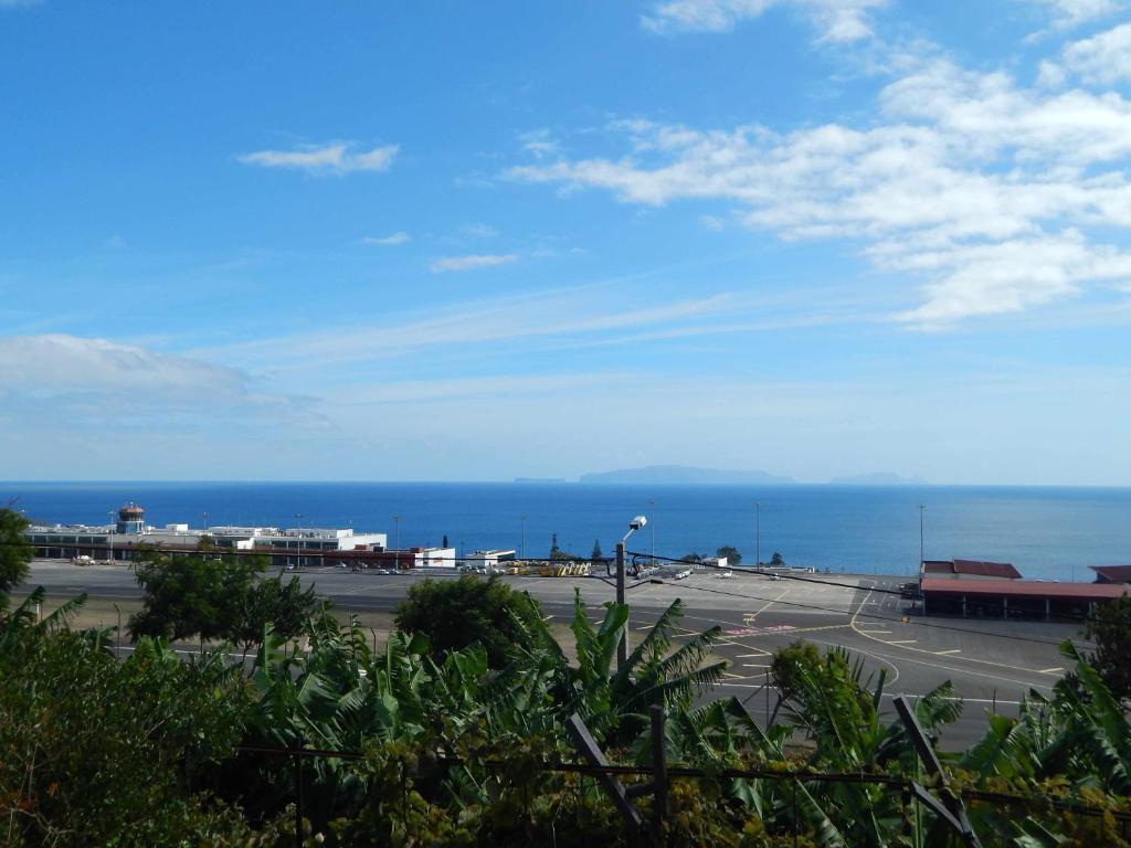 a view of a parking lot with the ocean in the background at Villas Madalena Chalets vista mar cWiFi in Santa Cruz