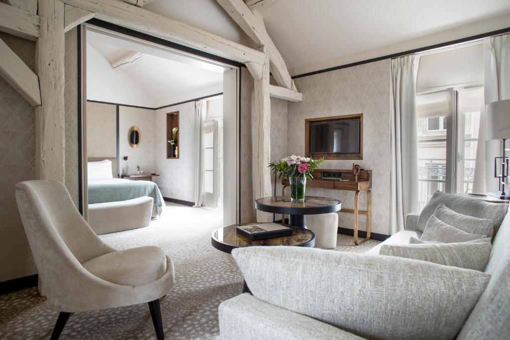 een woonkamer met een bed, een bank en een tafel bij Esprit Saint Germain in Parijs