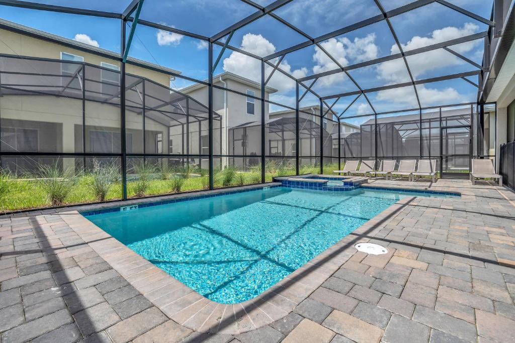 einen Pool in einem Gebäude mit einem Glashaus in der Unterkunft VILLA wPrivate Pool & Game Room near Disney in Kissimmee