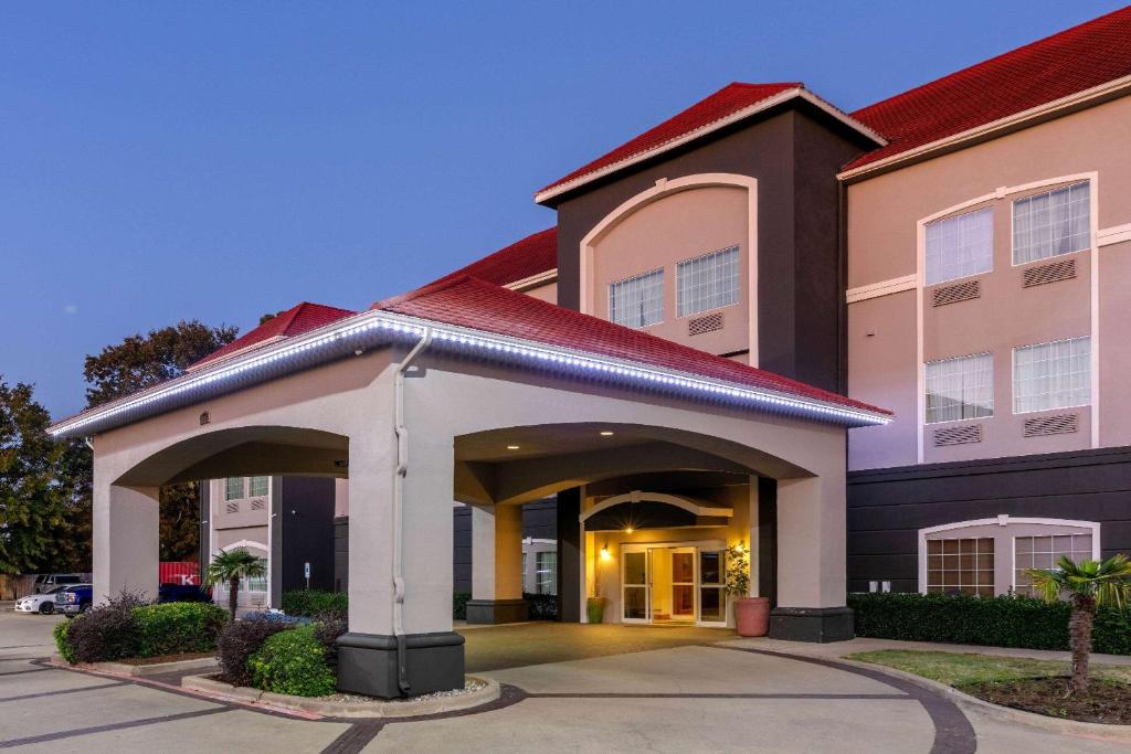 a hotel with a building with a garage at La Quinta by Wyndham I-20 Longview South in Longview